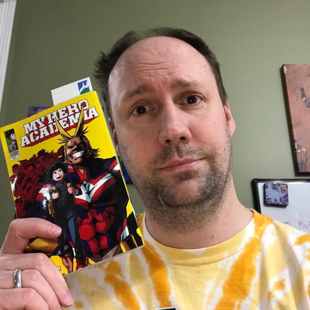 Matt holding up a copy of the first book of "My Hero Academia"