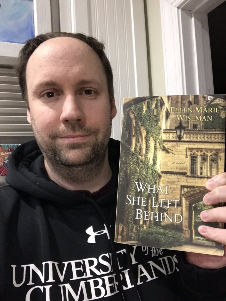 Matt holding up a copy of "What She Left Behind"
